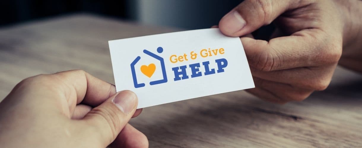 Hands Holding a Get and Give Help Card