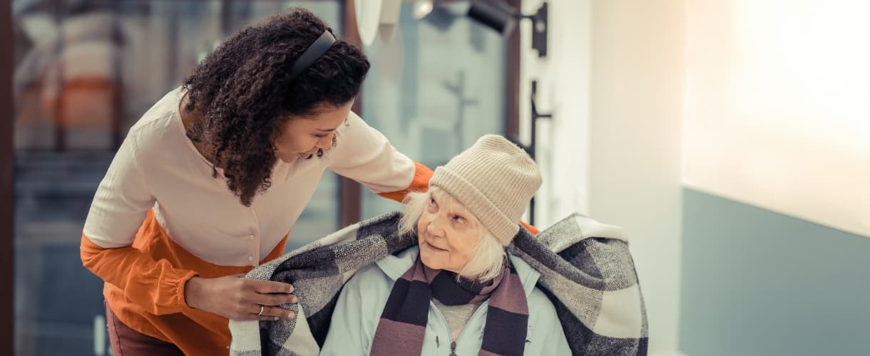 Woman Helping Elderly Lady in Chair